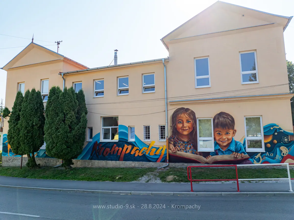 Maľba detí s knihou na fasáde budovy